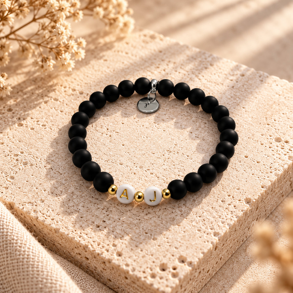 Verbunden – schwarzes handgefertigtes Polarisperlen-Armband mit Buchstaben von JI Handmade