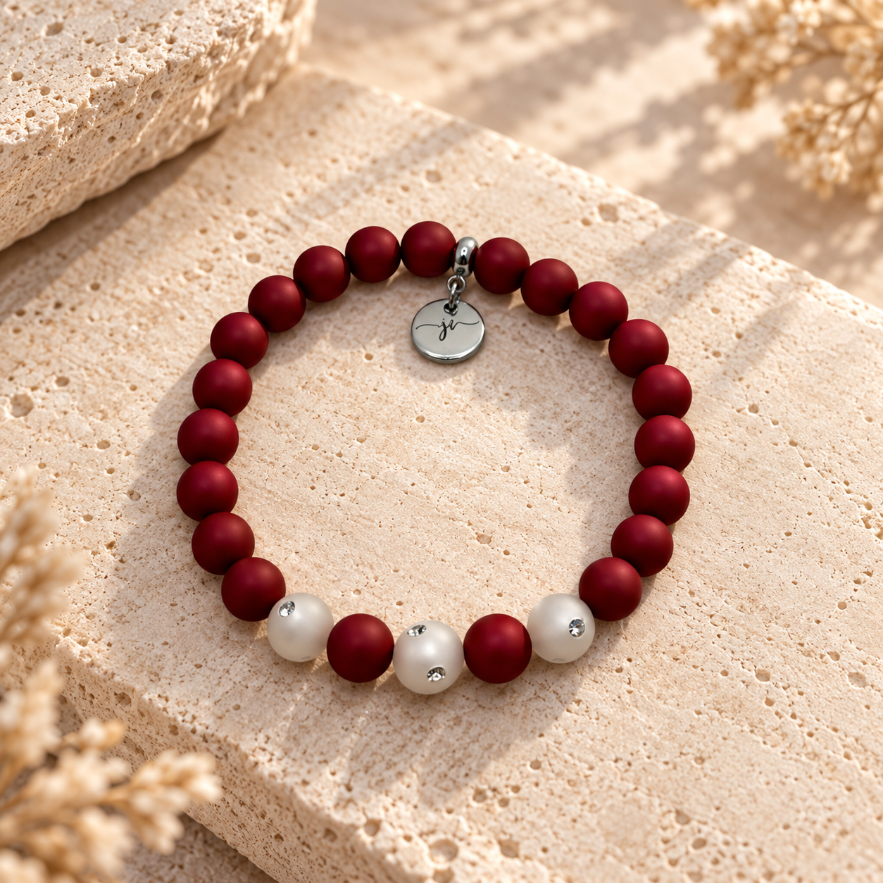 Rotes JI-Handmade-Armband mit hellen Akzentperlen und silberfarbenem Anhänger